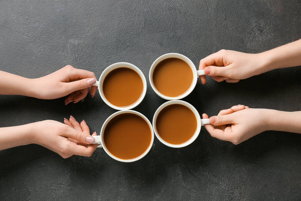 Mãos femininas e xícaras de café no fundo escuro - Foto, Imagem