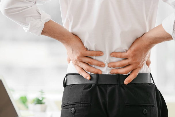 Young man suffering from back pain in office - Foto, Imagem