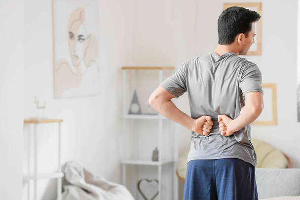 Junger Mann leidet zu Hause unter Rückenschmerzen - Foto, Bild