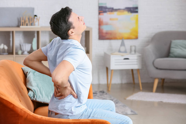 Young man suffering from back pain at home - Photo, image