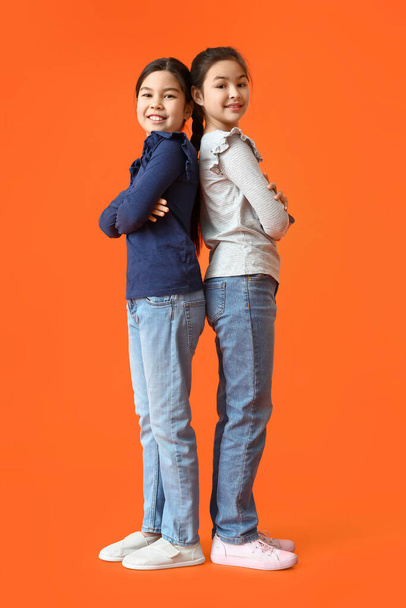 Cute little sisters on color background - Photo, image