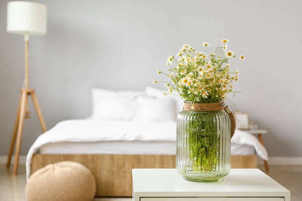 Váza s heřmánky na stole v ložnici - Fotografie, Obrázek