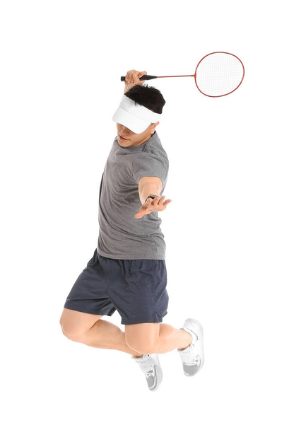 Beyaz arka planda zıplayan erkek badminton oyuncusu - Fotoğraf, Görsel
