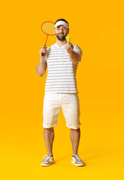 Sporty male badminton player on color background - Photo, Image