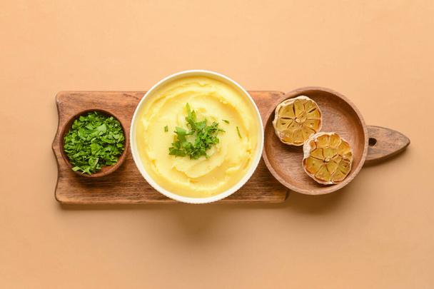 Bowl of tasty mashed potatoes with garlic on color background - Photo, Image