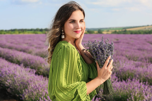 Beautiful young woman in lavender field - 写真・画像
