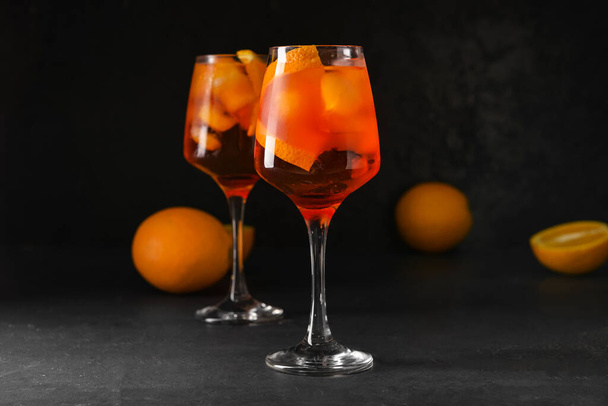 Gläser leckerer Aperol Spritz Cocktail auf dunklem Hintergrund - Foto, Bild