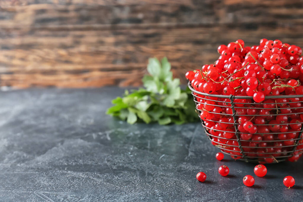 Basket with fresh red currants on table, closeup - Foto, afbeelding