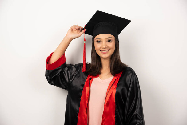 Feliz estudiante graduado en vestido posando sobre fondo blanco. Foto de alta calidad - Foto, imagen