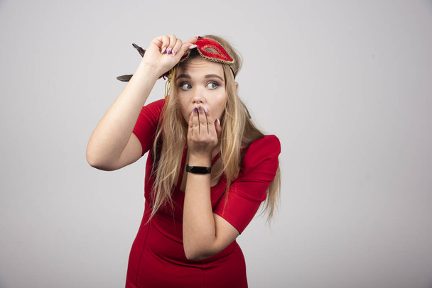 Young beautiful woman in red mask getting surprised. High quality photo - 写真・画像