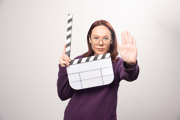 Young woman posing with a cinema tape on a white background . High quality photo - Foto, afbeelding