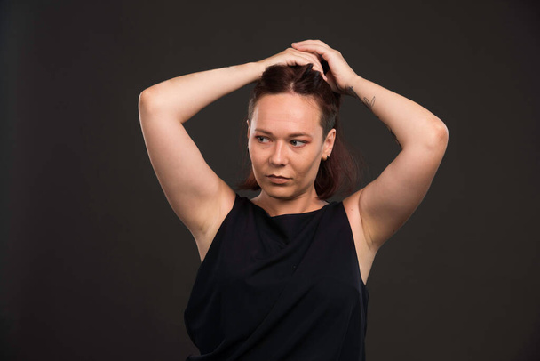 Female model in black shirt collecting hairs. High quality photo - Valokuva, kuva