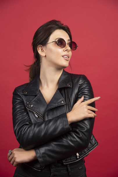 Cool girl in black leather jacket posing in black sunglasses. High quality photo - Photo, image