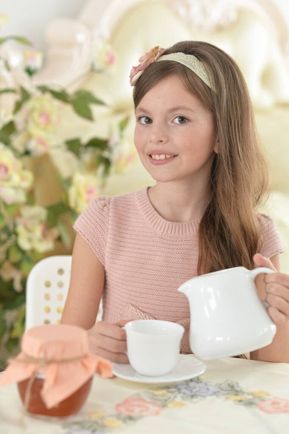 Smiling little girl holding big cup of tea - Foto, Bild
