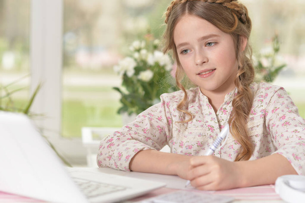 Nettes kleines Mädchen mit Laptop zu Hause  - Foto, Bild