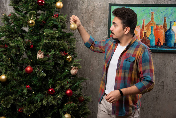 Молодой человек держит рождественский бал. Высокое качество фото - Фото, изображение