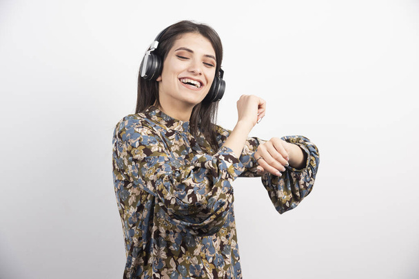 Jeune femme dansant et écoutant de la musique dans les écouteurs. Photo de haute qualité - Photo, image