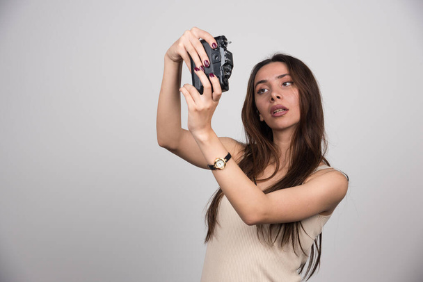 Hermosa mujer tomando selfies sobre fondo gris. Foto de alta calidad - Foto, Imagen