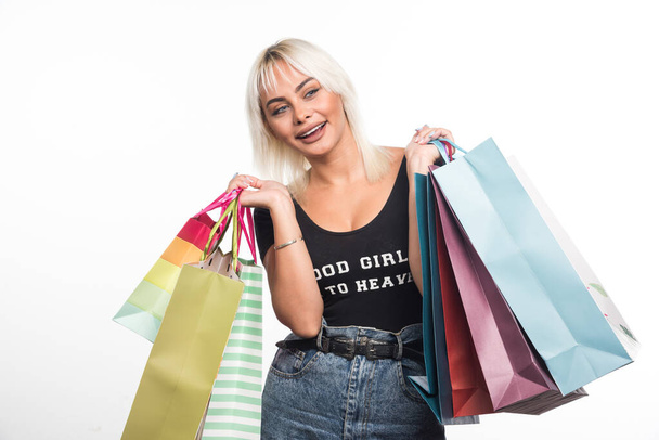 幸せな若い女性は白い背景にショッピングバッグを保持。高品質の写真 - 写真・画像