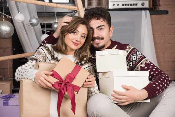 Romantische partners die liefdevol kerstcadeaus vasthouden. Hoge kwaliteit foto - Foto, afbeelding
