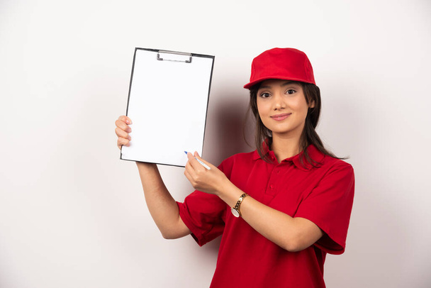 空のクリップボードで赤い制服を着た笑顔の女性。高品質の写真 - 写真・画像