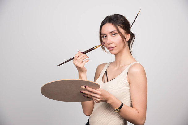 Young artist applying blush with brush. High quality photo - Foto, Imagem
