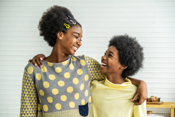 Happy Kids.Zwei süße entzückende Geschwister afrikanisch-amerikanische Kinder umarmen den Hals und lächeln, ältere Schwester umarmt kleinen Bruder am Hals - Foto, Bild