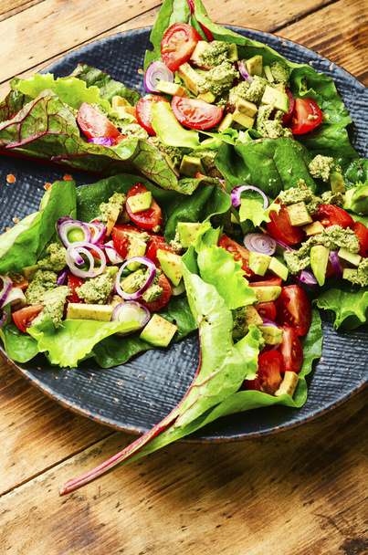 Avokádový salát, rajče s česnekovou omáčkou v listech charde.Letní vitaminový salát v talíři - Fotografie, Obrázek