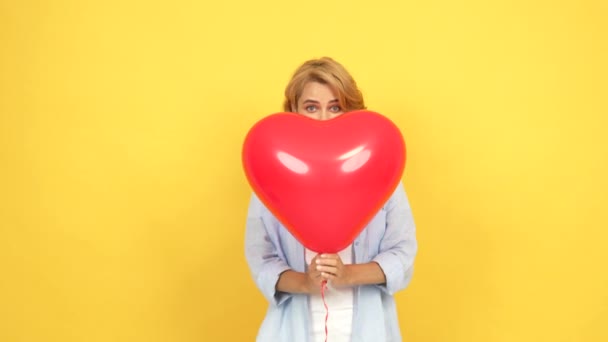 happy woman blow kiss and wink behind heart love party balloon, love - Footage, Video