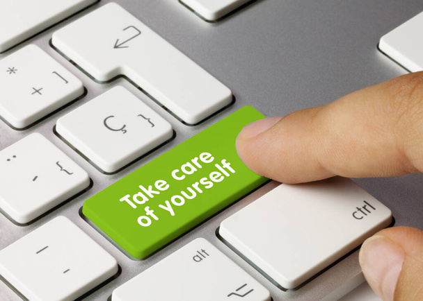 Берегите себя Написано на зеленой клавише металлической клавиатуры. Нажатие пальца. - Фото, изображение