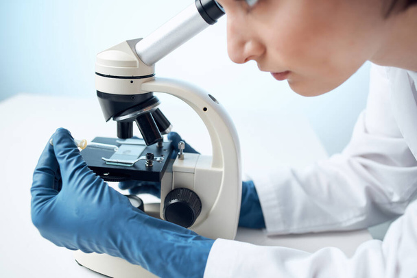 Nainen etsii läpi mikroskooppi diagnostiikka tiede tutkimus lähikuva - Valokuva, kuva