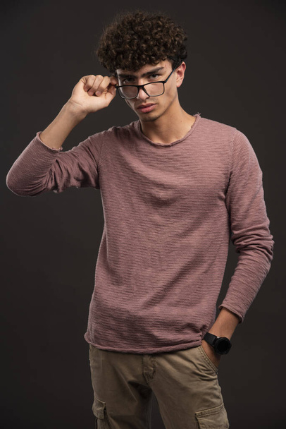 Νεαρό αγόρι με σγουρές τρίχες που φοράει γυαλιά. Υψηλής ποιότητας φωτογραφία - Φωτογραφία, εικόνα