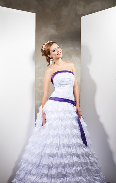The beautiful young woman in a wedding dress - Foto, Imagen