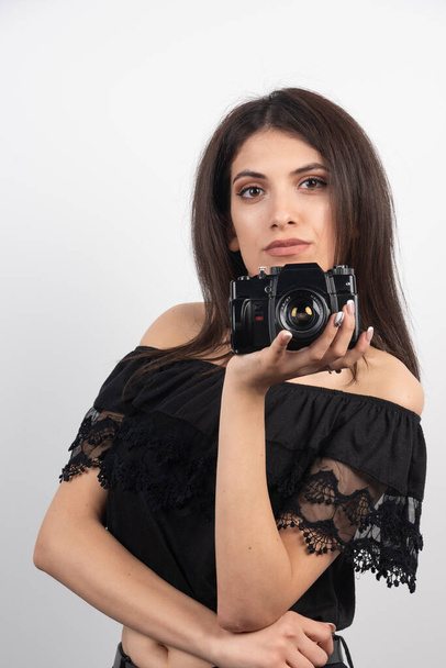 Pretty woman holding camera on white background. High quality photo - Foto, Imagem