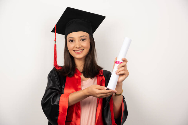 Studentin zeigt Diplom auf weißem Hintergrund. Hochwertiges Foto - Foto, Bild