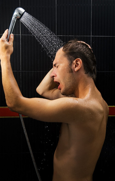 Young handsome man in a shower - 写真・画像
