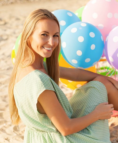 Donna sulla spiaggia con palloncini a pois colorati
 - Foto, immagini