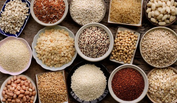 Çeşitli türde kuru organik tahıl ve tahıl tohumları tahtadan ve seramik kaseler koyu tonda, sağlıklı veya temiz gıda malzemeleri veya tarım ürünleri konsepti için. - Fotoğraf, Görsel