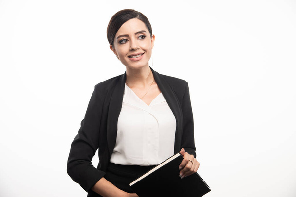 Smiling woman posing with notebook on white background. High quality photo - Φωτογραφία, εικόνα