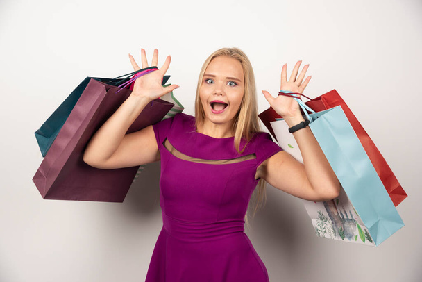 Boldog boltos kezében színes bevásárló táskák. Kiváló minőségű fénykép - Fotó, kép