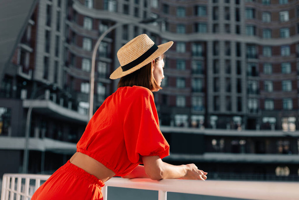 Mujer con estilo en ropa naranja al atardecer en el estadio de ciclismo posando - Foto, Imagen
