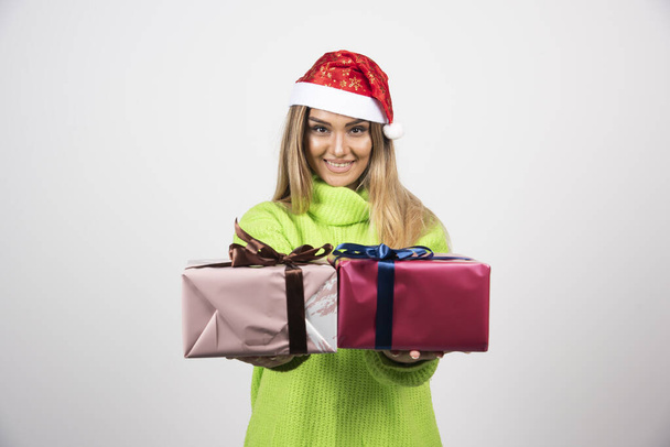 Young woman giving festive Christmas presents. High quality photo - Fotografie, Obrázek