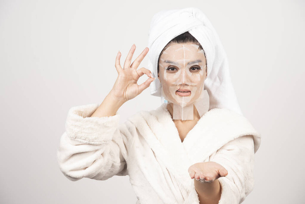 Woman wearing bathrobe and towel with facemask. High quality photo - Fotografie, Obrázek