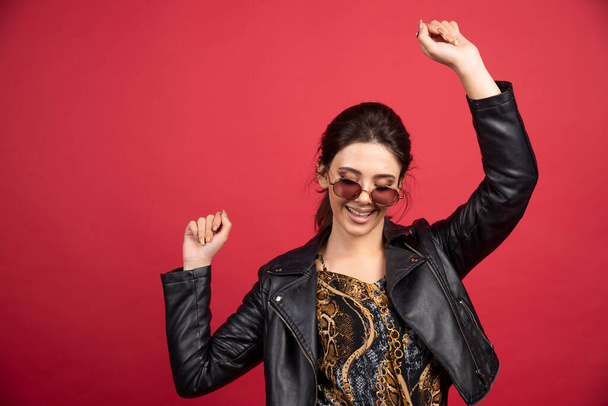 Cool girl in black leather jacket and sunglasses dancing. High quality photo - Photo, Image