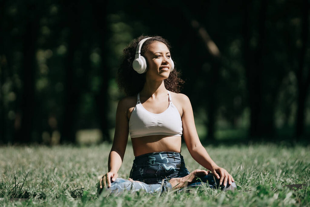 sporty woman in headphones relaxing to the music while sitting o - Photo, image