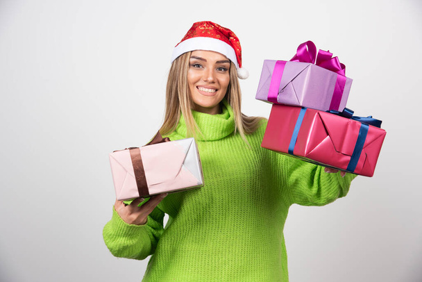 Młoda kobieta trzyma wiele świątecznych prezentów. Wysokiej jakości zdjęcie - Zdjęcie, obraz
