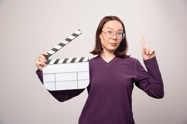 Jonge vrouw met een filmtape op een witte achtergrond. Hoge kwaliteit foto - Foto, afbeelding
