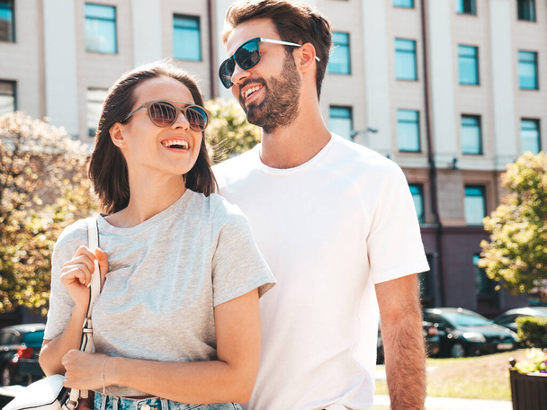Smiling beautiful woman and her handsome boyfriend. Woman in casual summer clothes. Happy cheerful family. Female having fun. Couple posing on the street background in sunglasses.Hugging each other - Valokuva, kuva