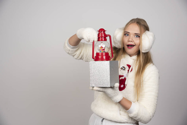 Femme blonde à l'oreille blanche montrant cadeau de Noël. Photo de haute qualité - Photo, image