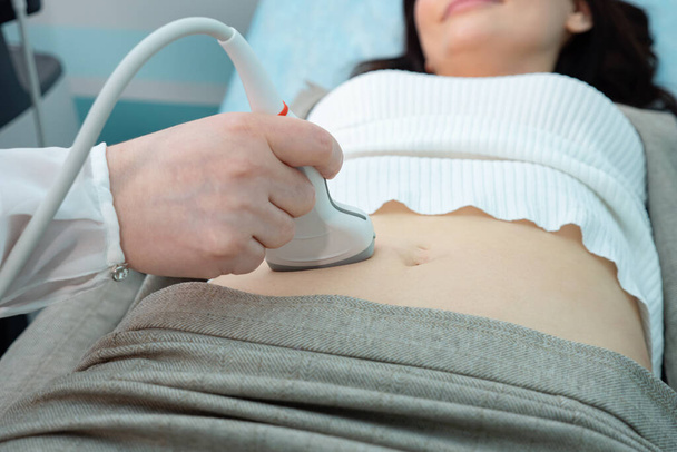 Médico mão faz ultra-sonografia de órgãos abdominais para paciente mulher tocando barriga nua com sonda - Foto, Imagem